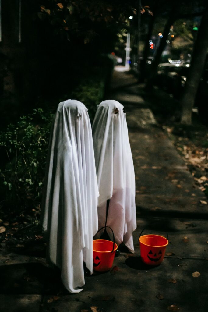 Children in bedsheet ghost costumes on a street
